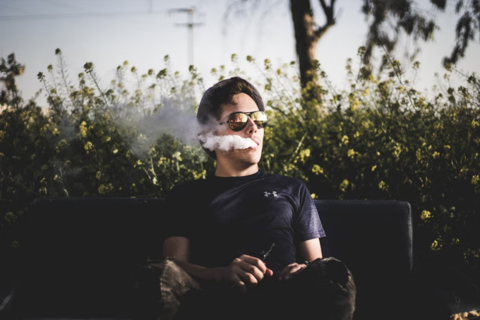 guy vaping on bench